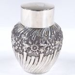 An Art Nouveau circular silver tea caddy, of half-fluted form with relief embossed floral