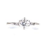 A 0.7ct solitaire diamond ring, 18ct white gold settings with tapered baguette-cut diamond