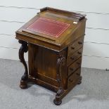 A 19th century rosewood Davenport with carved scroll supports