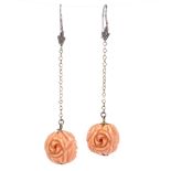 A pair of floral carved coral drop earrings, unmarked silver shepherd hook fittings, coral
