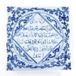A heavy Islamic porcelain tile with hand painted designs and script, 19.5cm across