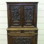An Antique Flemish oak cupboard, high relief floral carved and panelled doors, with 2 central frieze