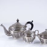 An Indian/Burmese unmarked silver 3-piece tea set, with all over relief embossed leaf decoration,