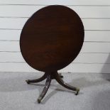 A circular mahogany tilt-top table on quadruple base, 35.5" across