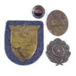 A Kuban arm shield, a German driver's badge, a wound badge, and lapel badge