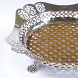 A circular silver fruit bowl, with central wicker panel and pierced rim, by Charles Alfred Alston,
