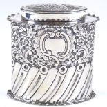 A late Victorian oval silver tea caddy, of half-fluted form with relief embossed floral and