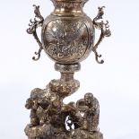A large Oriental bronze vase and cover, the base decorated with 2 figures standing by a river, the