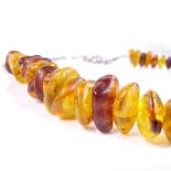 A large string of Baltic amber beads, on unmarked white metal popcorn link chain, length 96cm, 181.