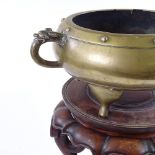 A Chinese bronze 2-handled incense burner, cast dragon decorated handles, raised on 3 feet, with