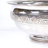 A large circular Portuguese silver fruit bowl, with relief embossed floral body and gilded interior,