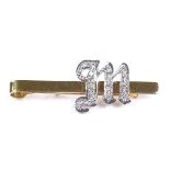 An unmarked gold diamond set initial M tie clip, unmarked settings test as 18ct gold, clip length