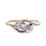 An 18ct gold 3-stone diamond crossover ring, central stone approx 0.1ct, total diamond content