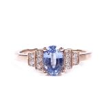 A 14ct rose gold solitaire sapphire ring, with diamond set stepped shoulders, oval-cut sapphire