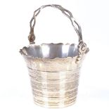 A small silver swing-handled pail bucket, with pierced handle and banded body, by William Comyns &