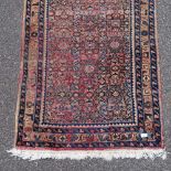 A red ground long wool runner, with blue border, 510cm x 92cm