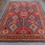 A large red ground handwoven wool rug, 355cm x 270cm