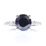 A 14ct white gold 1.85ct solitaire black diamond ring, with diamond set shoulders, total white