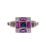 An Art Deco unmarked gold sapphire ruby and white sapphire panel ring, with scrolled shoulders,