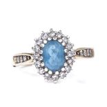 A 9ct gold blue topaz and diamond cluster ring, with diamond set shoulders, setting height 11.9mm,