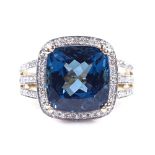 A 14ct gold blue topaz and diamond cluster ring, with diamond set shoulders, cushion-cut topaz