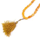 A string of polished graduated butterscotch amber beads, largest bead length 19.8mm, necklace length