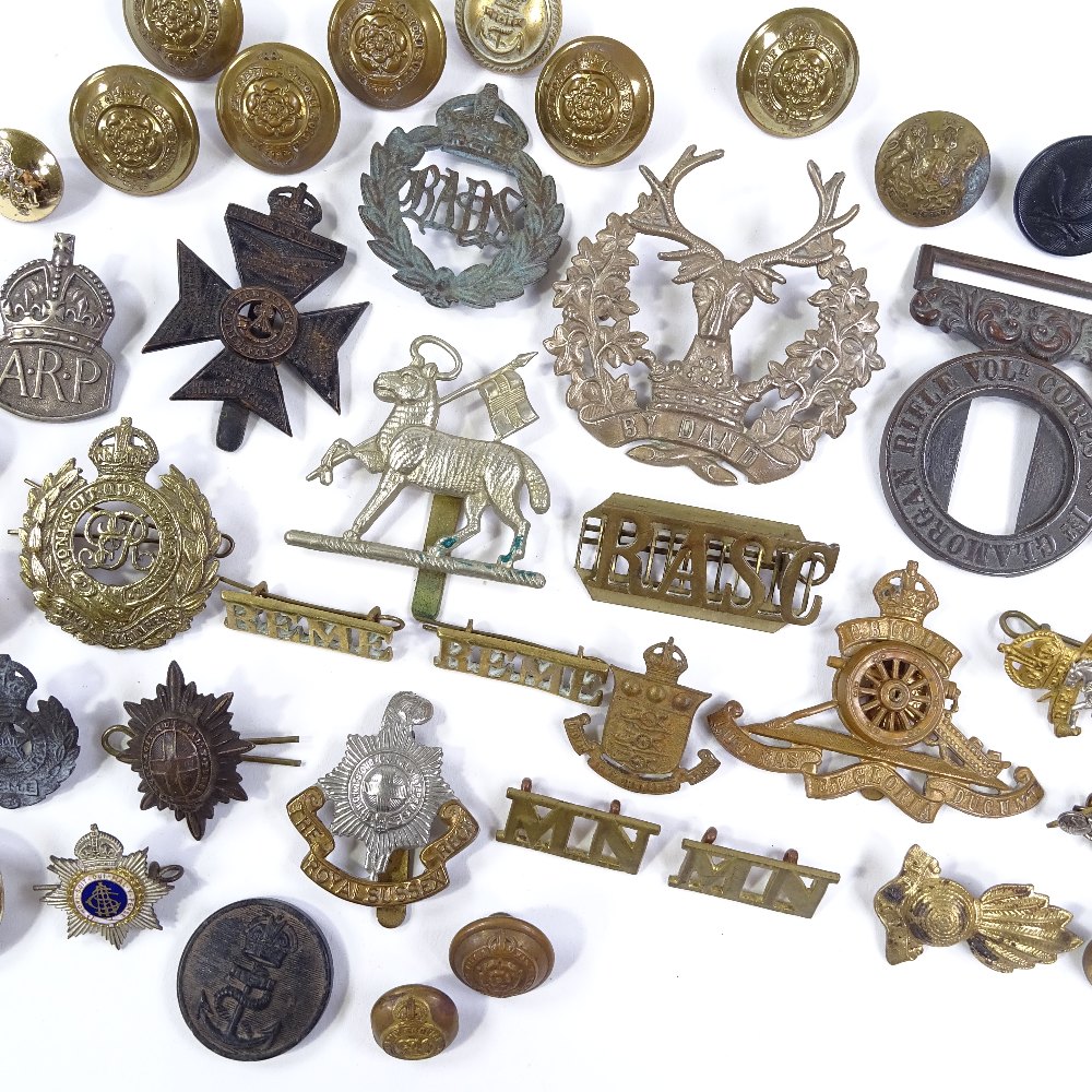 A collection of military cap badges and buttons