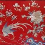 A Chinese silk embroidered picture, depicting exotic birds and flowers on red ground, framed,
