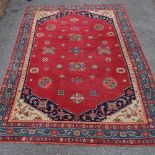 A large red ground Middle Eastern wool rug, 298cm x 222cm