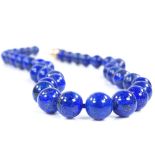 A carved and polished lapis lazuli bead necklace, with 9ct gold flowerhead clasp, bead diameter