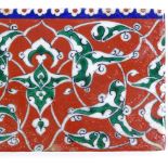 A Turkish Kutahya ceramic tile with painted decoration, length 21cm