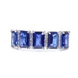 A 14ct white gold sapphire and diamond half-hoop ring, total emerald-cut sapphire content approx 3.