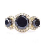 A 14ct gold black and white diamond trilogy halo ring, total black diamond content approx 3.6ct,