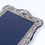 A modern sterling silver-fronted photo frame, with relief embossed foliate and floral decoration,