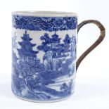 An 18th century blue and white porcelain mug with hand painted decoration and wicker covered metal