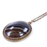 A large Victorian unmarked yellow metal banded agate memorial pendant necklace, with decorative hair