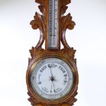 A Victorian carved oak-cased aneroid wall barometer and thermometer