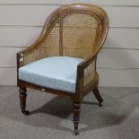 A 19th century Gillows style mahogany-framed Bergere tub chair with cane panelled back, turned