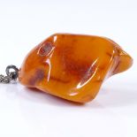 A large butterscotch amber pendant necklace, on unmarked silver rope twist chain, pendant height