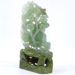 A Chinese carved green stone ornamental fruit, on soapstone stand, height 22cm