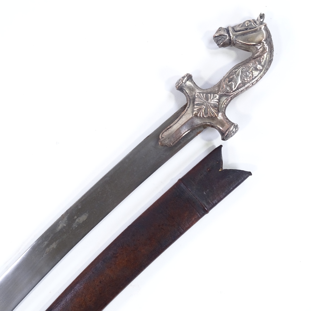 An Indian curved sword, with horsehead design hilt and lion and buffalo design grips, plain curved