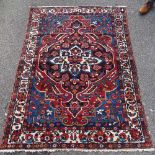A Persian handmade red and blue ground geometric design rug, 6'5" x 4'6"