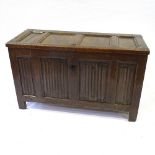 An early 18th century oak blanket chest with panelled lid and linenfold carved 4 panel front,