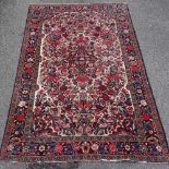 A Persian handmade red and blue ground floral pattern rug, 7'3" x 4'10"