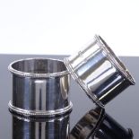 A cased pair of George V circular silver napkin rings, with beaded edges, by Robert Pringle &