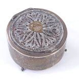 An Iraqi silver circular dressing table box, with applied gold heart panel and filigree surround,