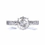 An 18ct white gold and platinum solitaire diamond ring, with diamond set shoulders, central