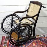 An Edwardian 3 wheel invalid chair by Harding of Bath, having a bergere back and seat