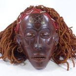 An African Chokwe Tribal carved wood mask, with beadwork fringe and rope hair, mask height 20cm