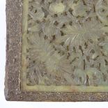 A Chinese carved and pierced hardstone plaque, mounted in a composition block, 18cm x 13cm
